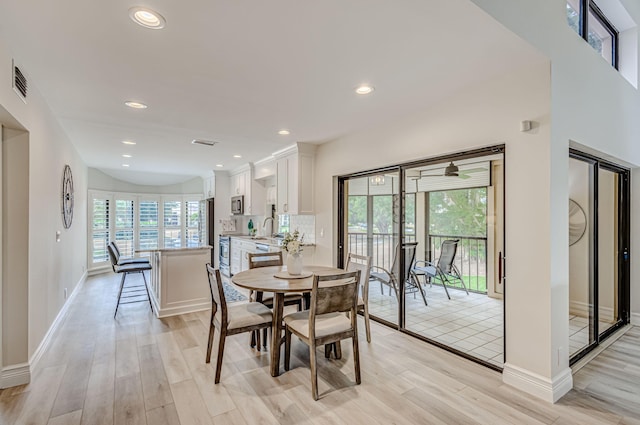 dining room with ceiling fan, sink, and light wood-type flooring