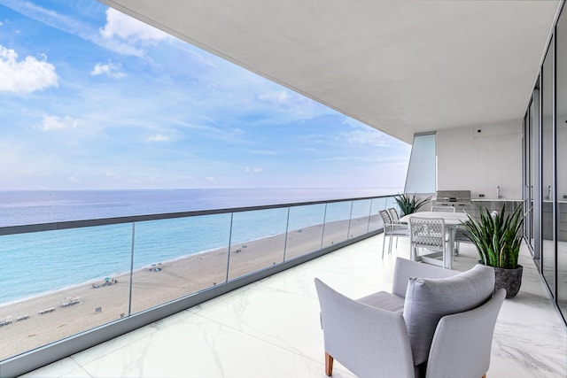 balcony with a view of the beach, a grill, and a water view