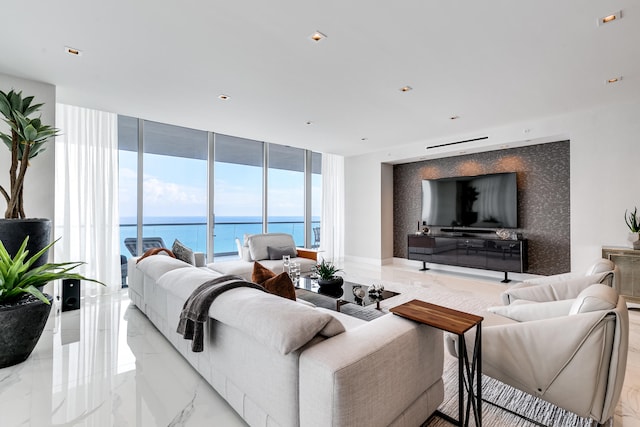 tiled living room featuring floor to ceiling windows and a water view