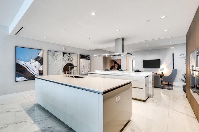 kitchen featuring light tile floors, white cabinetry, sink, and an island with sink