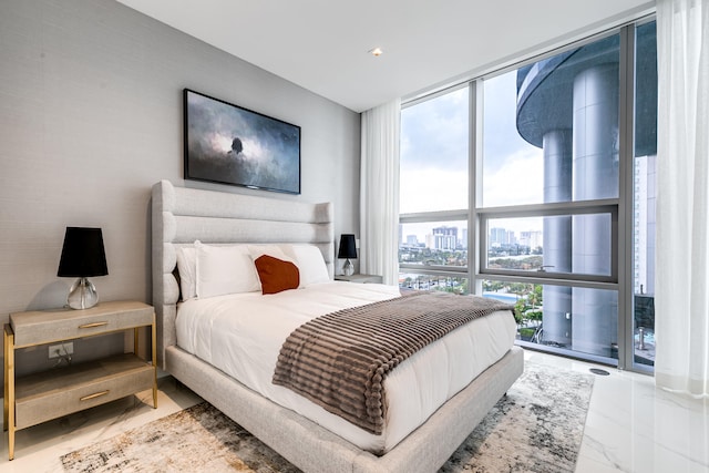 bedroom with expansive windows and light tile floors