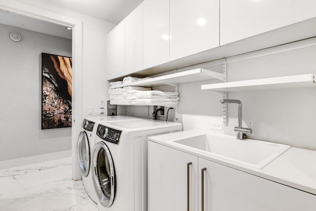 clothes washing area featuring washer hookup, sink, washing machine and clothes dryer, light tile flooring, and cabinets