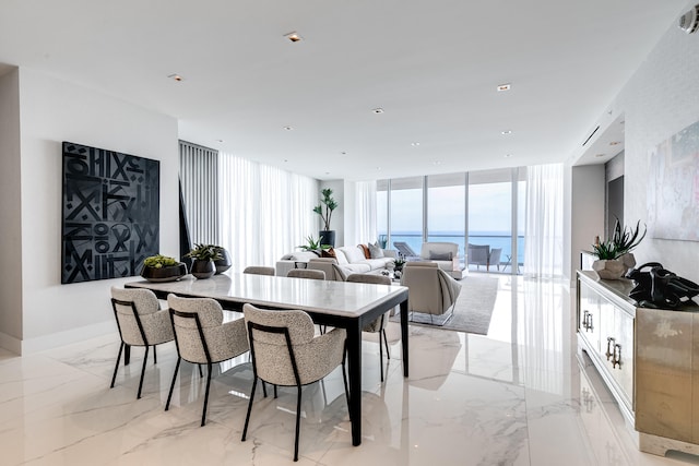 dining room featuring expansive windows, light tile flooring, and a water view