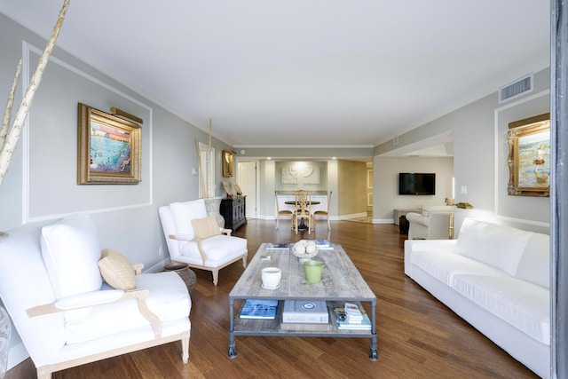 living room with dark hardwood / wood-style flooring and ornamental molding