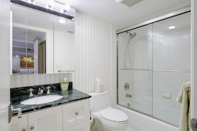 full bathroom with enclosed tub / shower combo, toilet, and oversized vanity