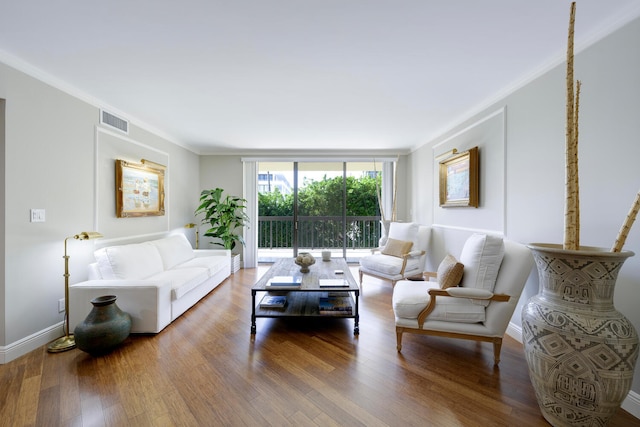 living room with wood-type flooring and ornamental molding