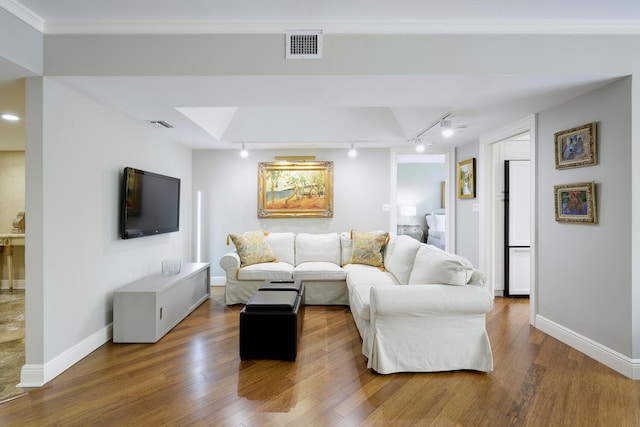 living room with crown molding, dark wood-type flooring, and track lighting