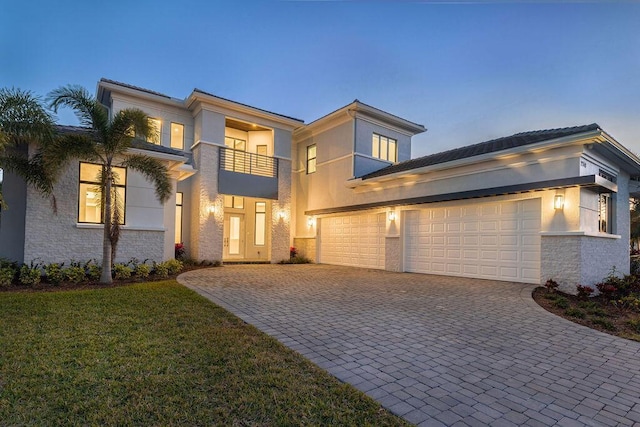 modern home featuring a yard, a balcony, and a garage