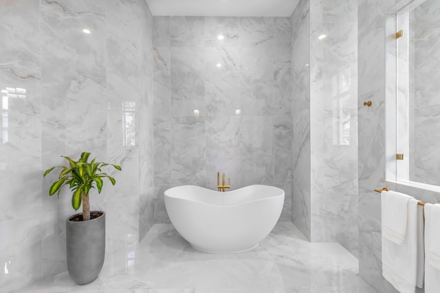 bathroom with a bathing tub and tile walls