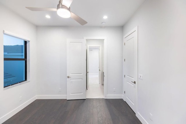 empty room with dark hardwood / wood-style floors and ceiling fan