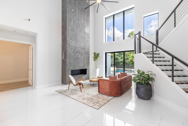 living room featuring a large fireplace and a towering ceiling