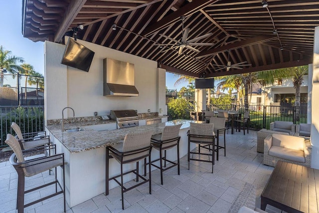 view of patio / terrace featuring grilling area, area for grilling, an outdoor wet bar, and ceiling fan