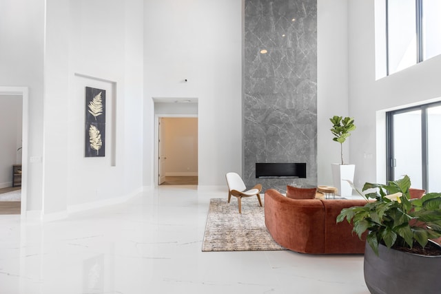 living room featuring a premium fireplace and a towering ceiling