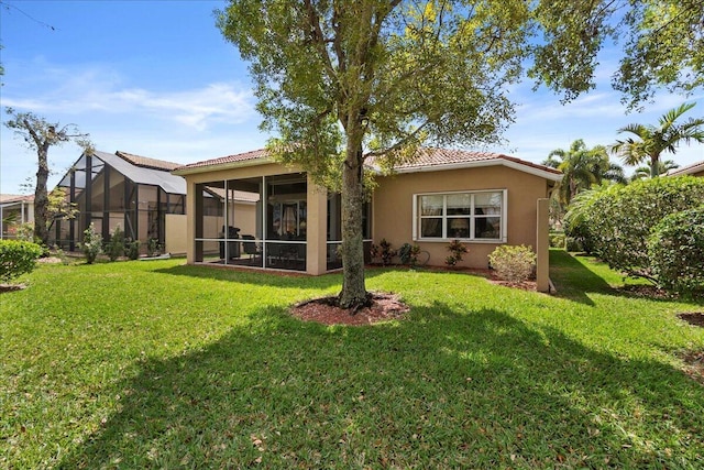 8839 Via Avellino, Lake Worth, FL 33467 - rear view of house featuring a lawn, stucco siding, a tile roof, and a sunroom