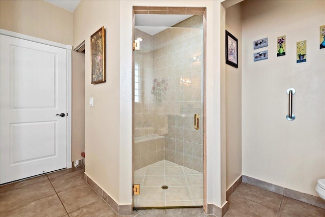 bathroom featuring an enclosed shower, toilet, and tile flooring