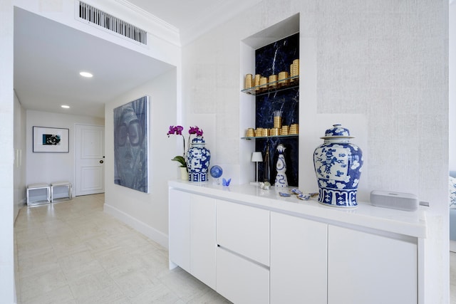 bar featuring white cabinets, light tile floors, and ornamental molding