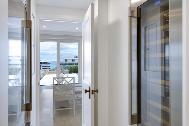 hallway with light tile flooring and a water view