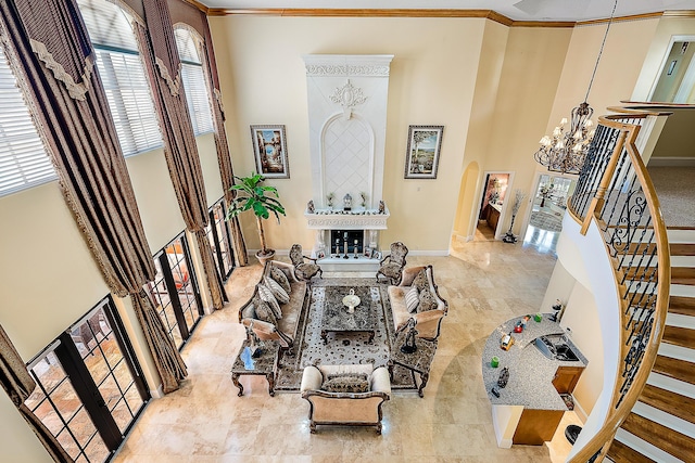 interior space with ornamental molding, a towering ceiling, and an inviting chandelier