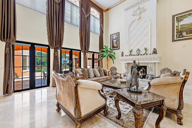 living room featuring ceiling fan, a fireplace, and a high ceiling