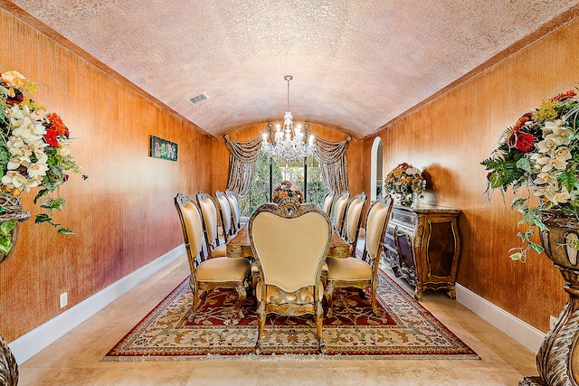 dining area with vaulted ceiling, brick ceiling, and a chandelier