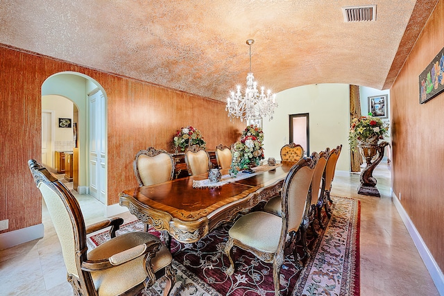 dining area featuring brick ceiling, wooden walls, a chandelier, and vaulted ceiling