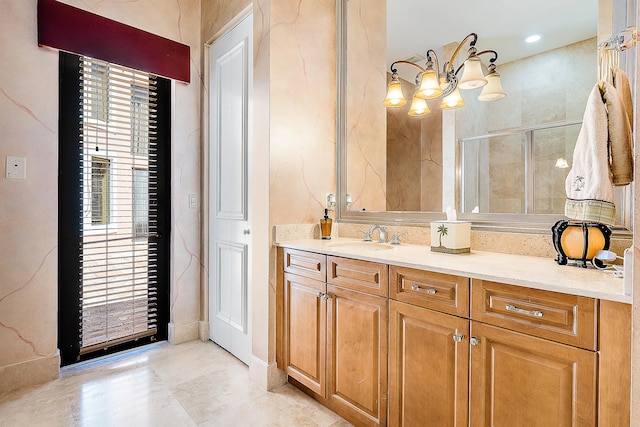 bathroom with a shower with door, vanity, and an inviting chandelier