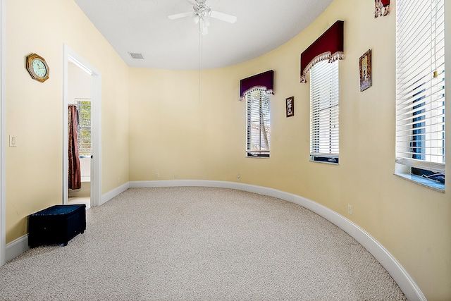 carpeted spare room featuring ceiling fan