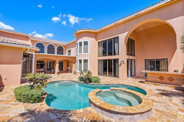 view of swimming pool with an in ground hot tub and a patio