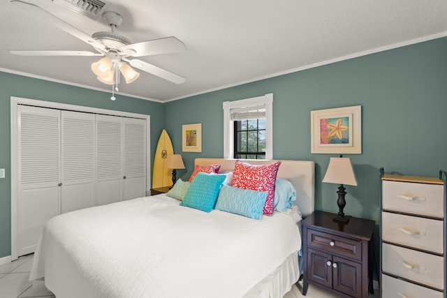 tiled bedroom with ceiling fan, ornamental molding, and a closet