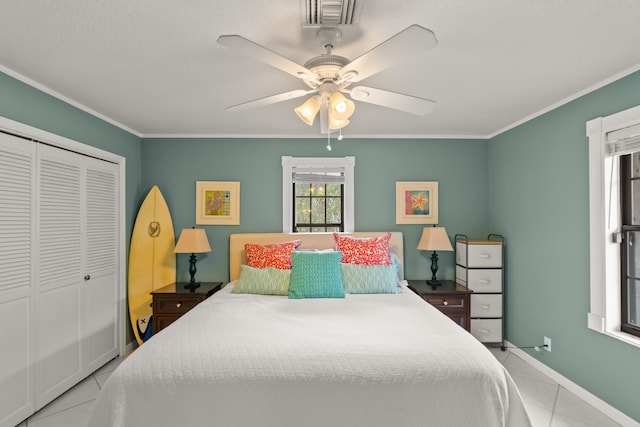 bedroom featuring a closet, ceiling fan, light tile patterned floors, and crown molding