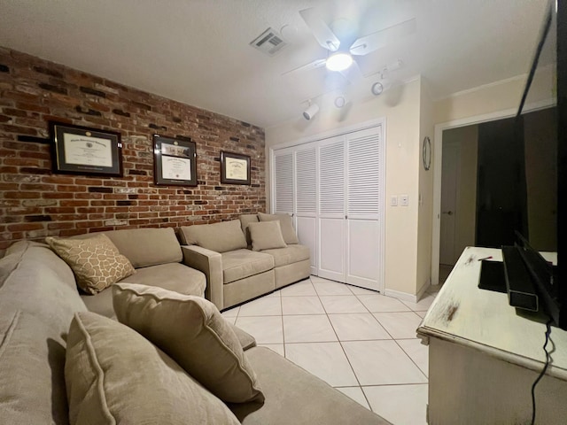 tiled living room featuring ceiling fan and brick wall