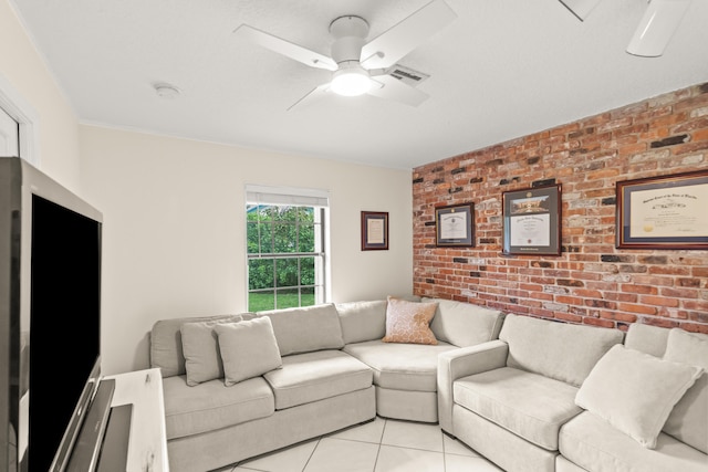 living room featuring ceiling fan, light tile patterned flooring, and brick wall