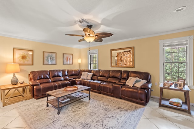 living room with ceiling fan, light tile patterned flooring, ornamental molding, and a healthy amount of sunlight