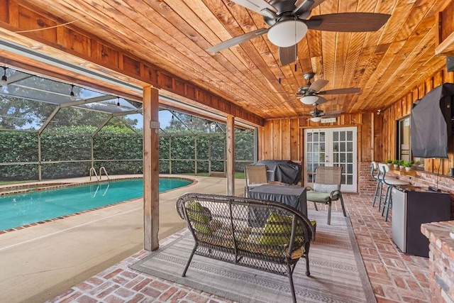 sunroom / solarium featuring wooden ceiling, french doors, and ceiling fan