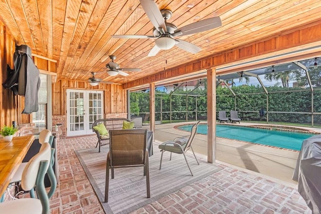 sunroom / solarium with ceiling fan, french doors, a pool, and wood ceiling