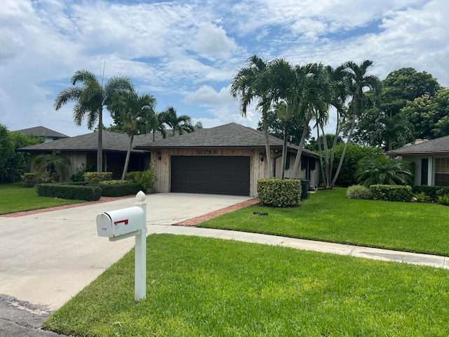 single story home featuring a garage and a front lawn