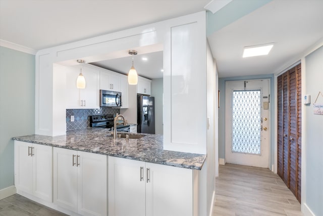 kitchen featuring dark stone counters, hanging light fixtures, white cabinets, light hardwood / wood-style floors, and stainless steel refrigerator with ice dispenser