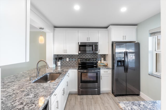 kitchen featuring stone counters, sink, stainless steel appliances, white cabinets, and tasteful backsplash