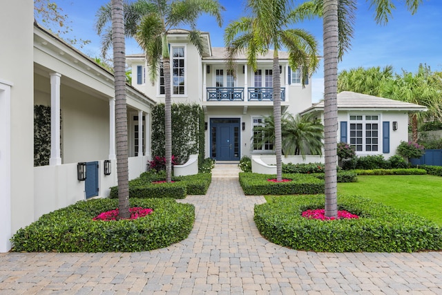 view of front of home featuring a front yard and a balcony