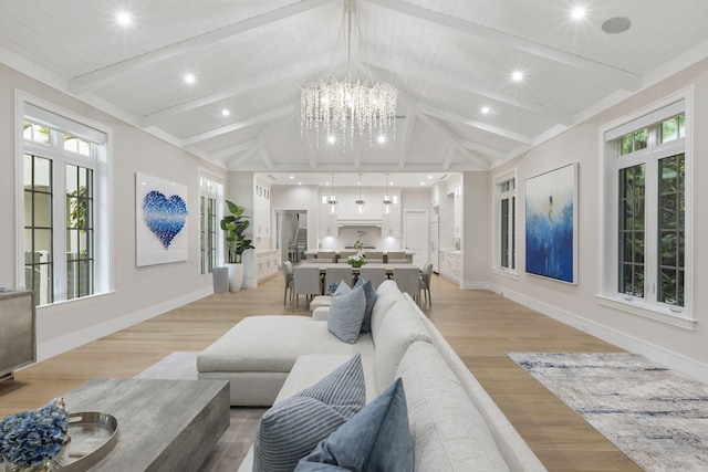 living room featuring lofted ceiling with beams, light wood-type flooring, wooden ceiling, and an inviting chandelier