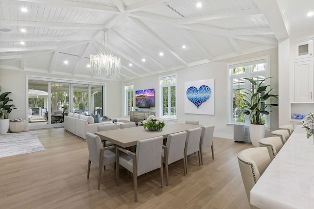 dining space with a wealth of natural light, beam ceiling, and light hardwood / wood-style floors