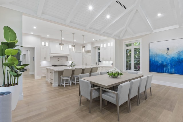 dining space featuring light wood-type flooring, wood ceiling, beamed ceiling, and high vaulted ceiling