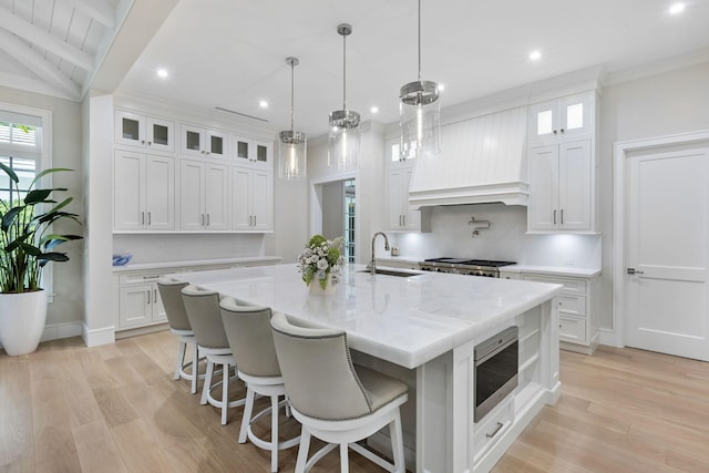 kitchen with a large island, sink, and white cabinetry