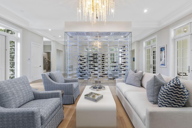 living room with light hardwood / wood-style flooring, a chandelier, and ornamental molding