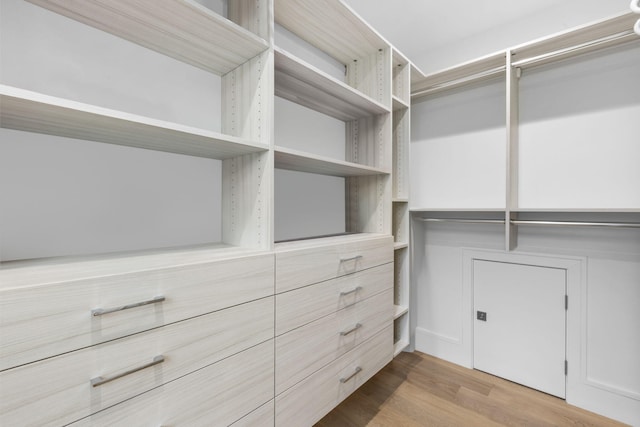 walk in closet with light hardwood / wood-style floors