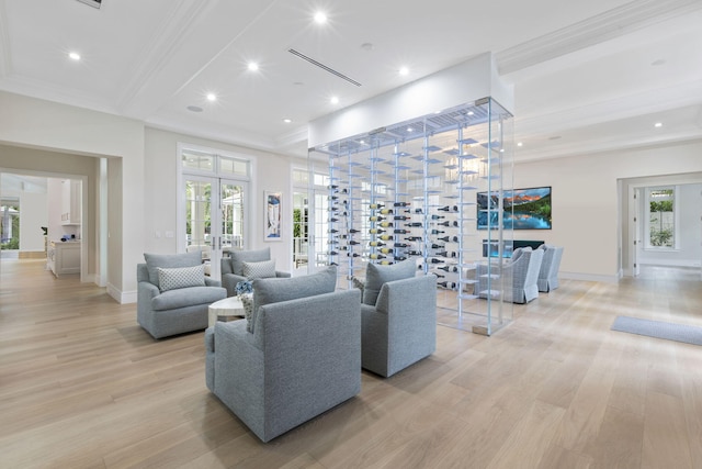 living room with light wood-type flooring, beam ceiling, ornamental molding, and french doors