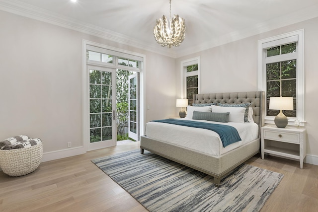 bedroom featuring access to outside, crown molding, light hardwood / wood-style floors, and a chandelier