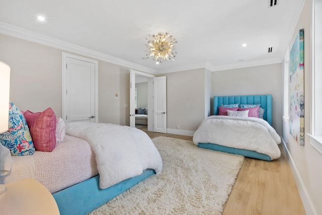 bedroom featuring ornamental molding, hardwood / wood-style floors, and a notable chandelier