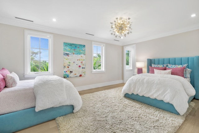 bedroom with light hardwood / wood-style floors, ornamental molding, and a notable chandelier