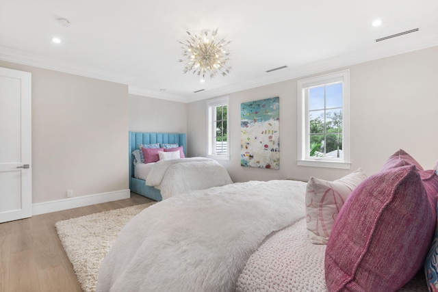 bedroom with crown molding, light hardwood / wood-style floors, and a notable chandelier